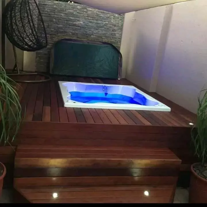 Built-in hot tub on a wooden deck at night
