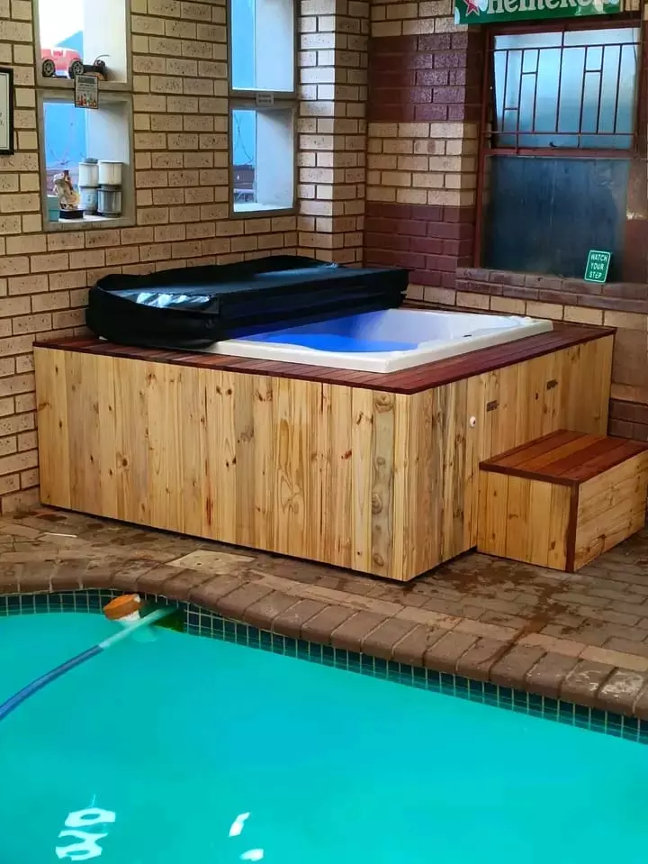 Custom wooden-paneled jacuzzi hot tub next to an indoor swimming pool