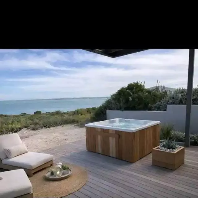 Wooden hot tub on a deck overlooking the ocean