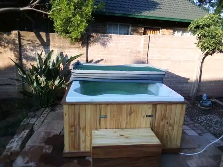 Outdoor wooden hot tub in a sunny backyard